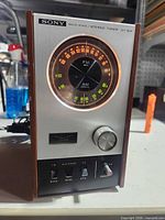 Front view of Sony ST-80F tuner powered on showing illuminated dial and controls