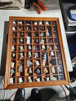 overall view of wooden display case filled with thimbles
