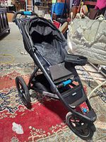Front left view of Thule Urban Glide jogging stroller showing frame, wheels and child tray