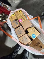 Nine boxed toner cartridges in a bag, some boxes hand-labeled by color