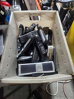 Top view of tote showing contents of assorted remote controls