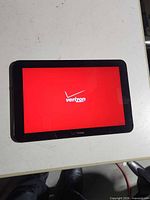 Front view showing powered-on screen with Verizon logo