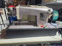 Front view of Kenmore sewing machine mounted in case base