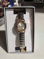 Front view of boxed wristwatch showing dial and band