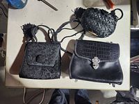 Overview of three black purses on table
