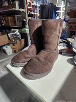 Pair of UGG brown suede mid-calf boots on table