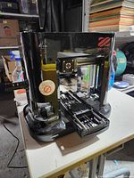 Front view of incomplete XYZprinting 3D printer showing logo and open chassis
