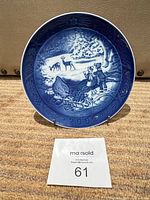 Front view of blue porcelain Christmas collector plate dated 2002 on stand