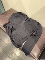 Full view of black Prada quarter-zip pullover laid flat