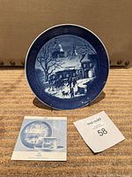 Front view of Royal Copenhagen 1995 Christmas plate on stand with leaflet