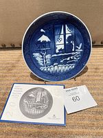 Front view of Royal Copenhagen 2001 Christmas plate with booklet and lot card