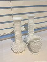 Three Brody milk glass hobnail vases grouped together