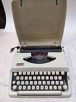 Typewriter with lid open showing keyboard and platen