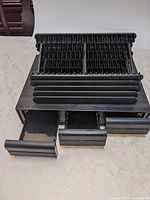 Cassette cabinet with drawers open showing slotted interiors, CD racks stacked on top