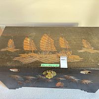 Top view showing carved painted sailing ships, brass latch, measurement note