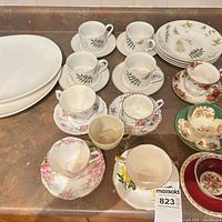 Entire assortment laid out on countertop showing platters, Gibson bowls with saucers and plates, and bone-china trios