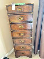 Full front view of tall narrow chest, drawers closed