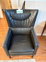 Front view of dark brown leather wingback armchair