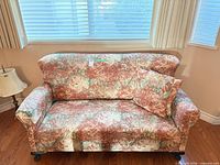 Front view of floral loveseat with cushion