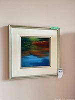 Full view of framed square painting on wall showing frame, mat and overall artwork