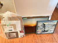 Group view of framed pieces and bagged art supplies