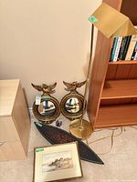 Group shot of two mirrors, floor lamp, framed art and wall plaque