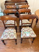 Front view of six dining chairs showing wood frames and chevron upholstery