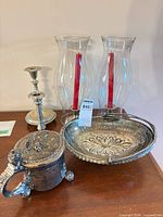 Entire lot showing glass hurricanes, red tapers, candlestick, lidded cup, tray
