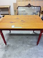 Full view of rectangular pine table with red legs