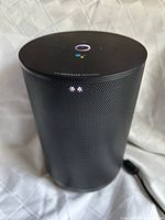 Front angled view showing cylindrical speaker body, grille, control panel