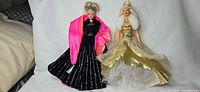 Both Barbie dolls standing side by side showing full outfits