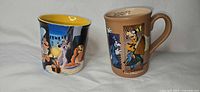 Two Disney mugs side by side, Lady and the Tramp left, Goofy right