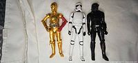 Wide shot of three 12-inch Star Wars figures: C-3PO, Stormtrooper, black trooper