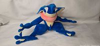 Full view of Greninja plush in seated pose