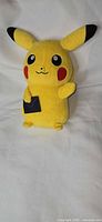 Front view of Pikachu plush showing envelope patch and facial features