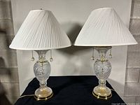 Front view of both cut crystal brass lamps with shades