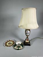 Lamp, plate, teacup and saucer grouped