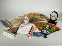 Group view of vase, fans, diorama, boxes and dish