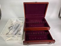 Flatware chest open with utensils bagged in bin