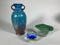 Blue/teal Dale Tiffany vase, green bust paperweight, clear floral paperweight group shot