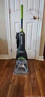 Front view of Bissell upright carpet cleaner showing brand logo and clear nozzle