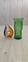 Overall shot of both items – green vase left, amber tear-drop paperweight right