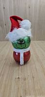 Front view of glittered glass Grinch figure with Santa hat