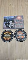 Front view of two books and two round Harley-Davidson trivets