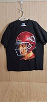 Front view of black T-shirt on hanger showing Joe Montana graphic