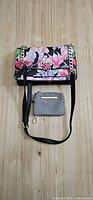 Front view of floral purse and grey coin pouch on wooden surface