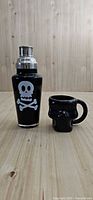 Cocktail shaker and skull mug side-by-side