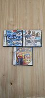 Three Nintendo DS game cases laid out: The Smurfs 2, FIFA 08 Soccer, Babysitting Mania