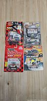 Front view of four sealed NASCAR die-cast packages on wood surface