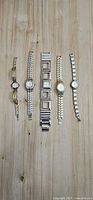 Five assorted ladies watches laid out